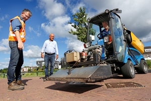 een ingehuurd bedrijf brandt onkruid weg en een medewerker van de BEL Combinatie controleert dat